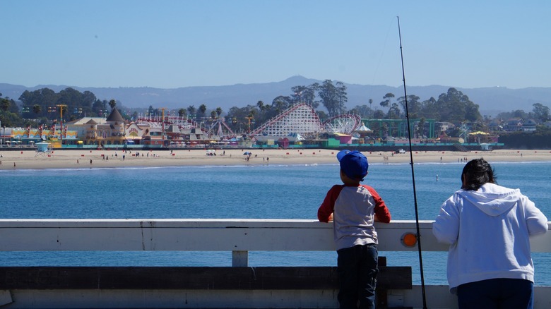 Mom and kid fishing from the Santa Cruz Wharf with the Santa Cruz Beach Boardwalk in the background