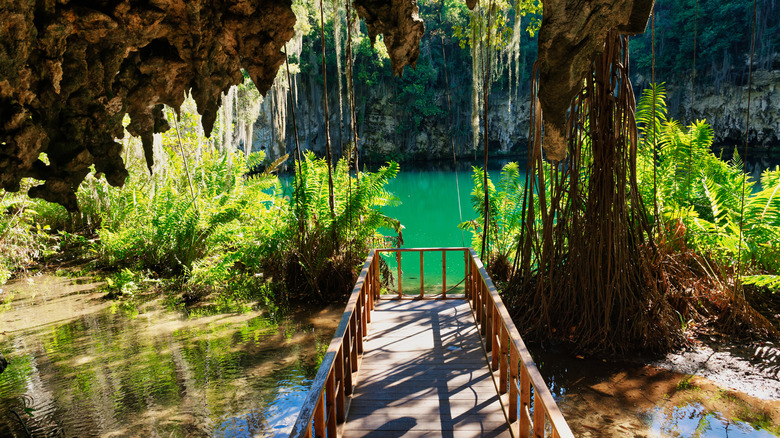 A platform leading out to a turquoise lake in Three Eyes National Park in Santo Domingo