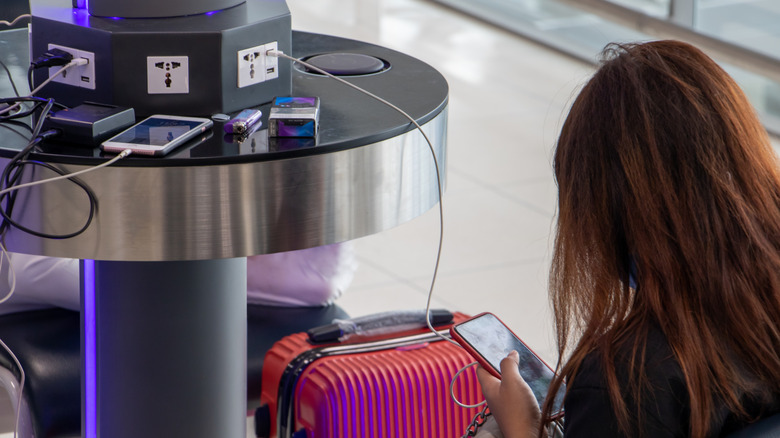 A traveler plugged into a public USB port at an airport