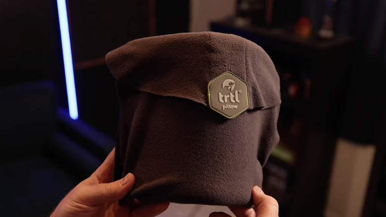 The Trtl compact travel pillow held in someone's hands