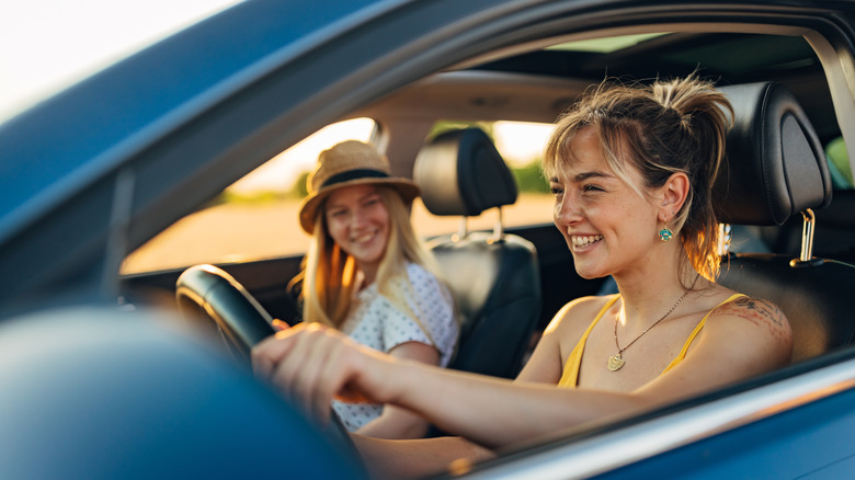 Two smiling young women in a car