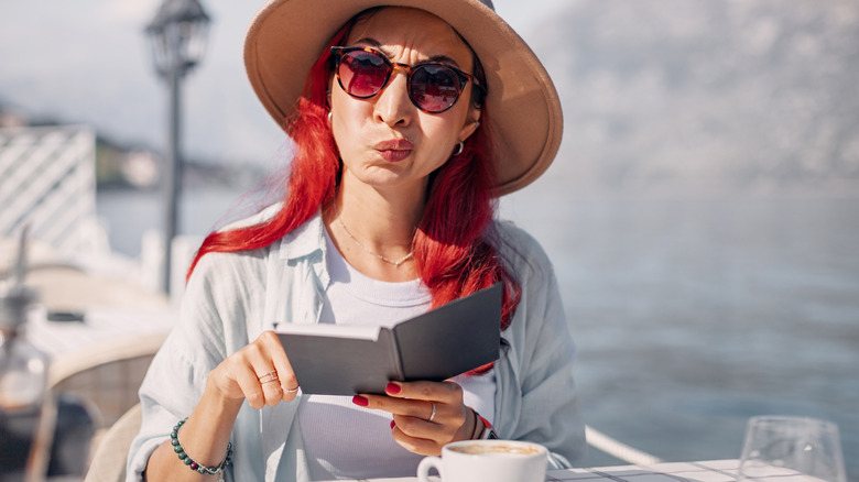 A person confused and displeased by their cafe bill