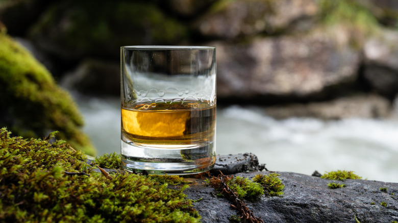 Dram of whisky sitting on streamside rocks