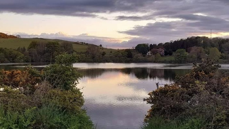Kinghorn Loch and shoreline under a cloudy sunsetting sky