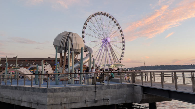Ferris wheel and jellyfish structure on Pier 58 in Seattle's Waterfront Park during sunset