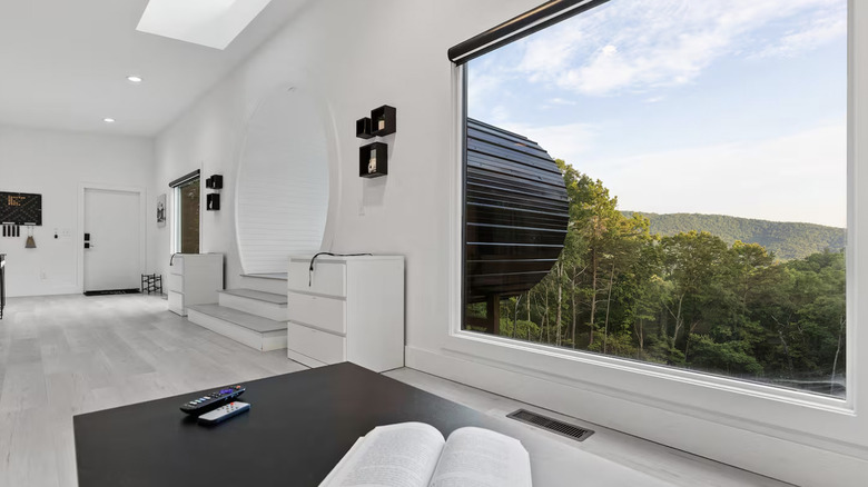 The interior of the Lens Lodge with a gorgeous view of the wooded mountains through a picture window