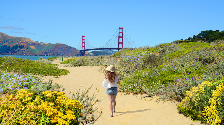 A woman walking with the Golden Gate Bridge in the background