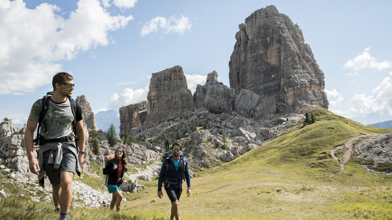 Group of hikers trekking uphill toward the Cinque Torri in the Dolomites, Italy