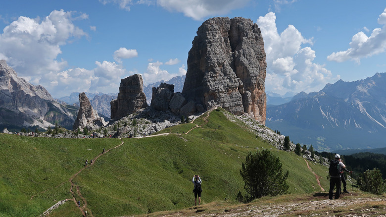 Hikers walking along a trail leading to the Cinque Torri in the Dolomites, Italy