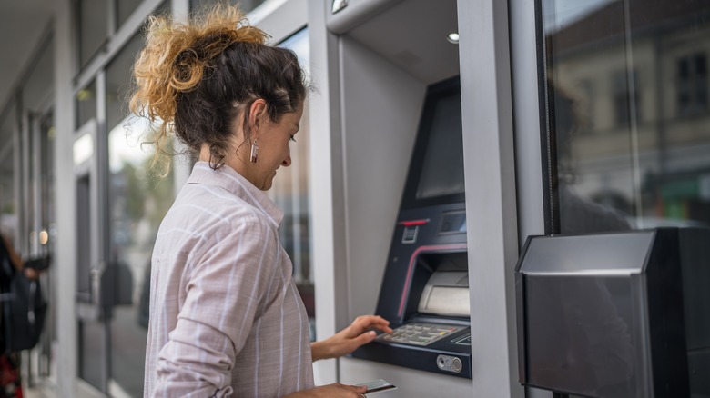 A woman withdrawing cash from an ATM.