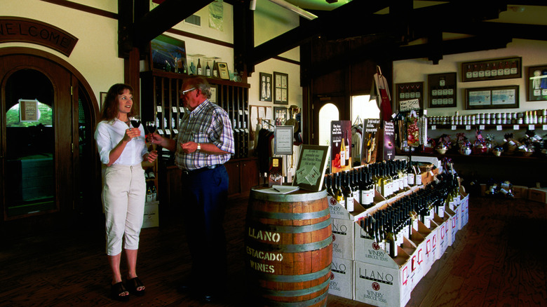 A man and woman converse in the tasting room of a Texas winery
