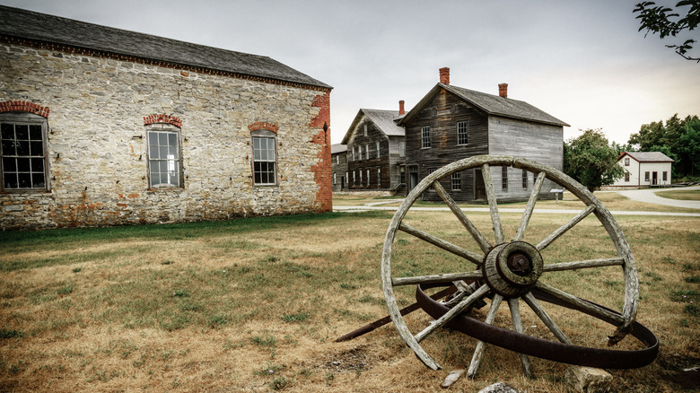A wooden wheel and building ruins in the ghost town of Fayette
