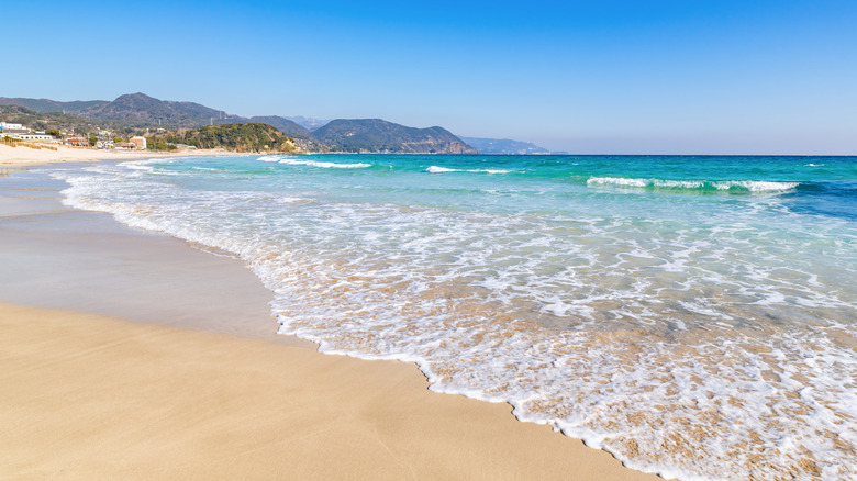 Turquoise sea lapping up on white sand at a beach in Shimoda, Japan