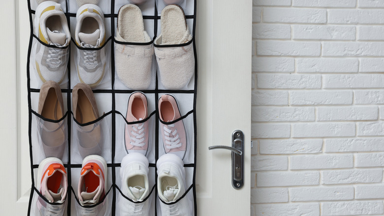 Hanging shoe organizer on door filled with shoes