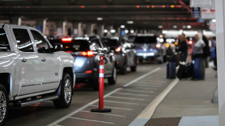 A line of vehicles waiting to pick up passengers outside an airport.