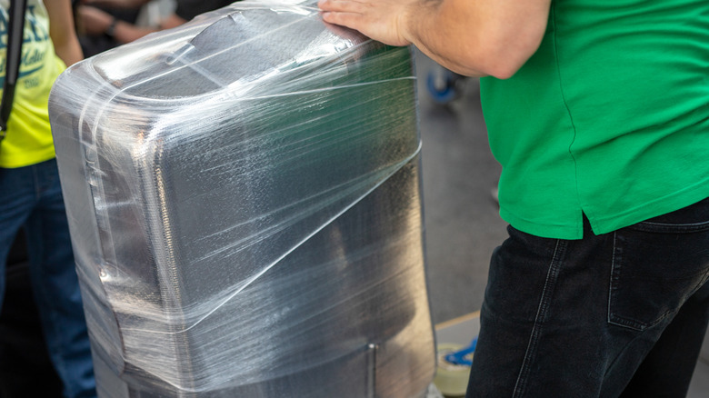 Luggage being wrapped in plastic at the airport