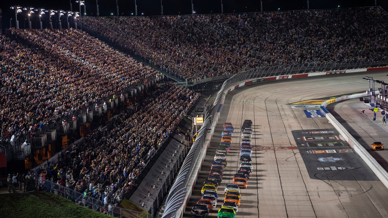 Cars on the track at night in the Darlington Raceway stadium