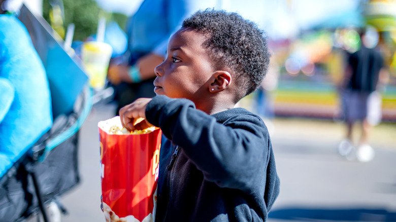 Young boy enjoying popcorn at a festival