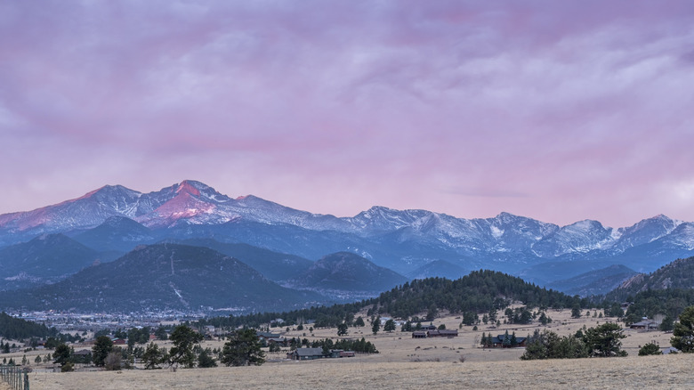 A vibrant pink alpine glow at sunrise on Longs Peak above Estes Valley, Colorado