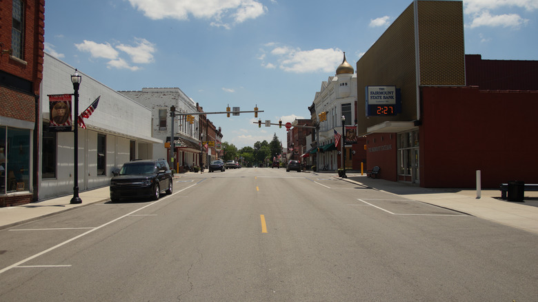 The main street in Fairmount, Indiana, with local shops, cars, and old buildings on a sunny day