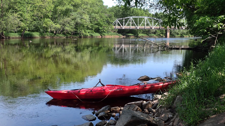 A kayak on the Black River near Greenwood, Wisconsin, with the Historic Highway G Bridge in the background
