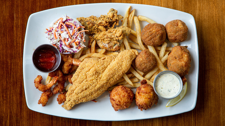 Assorted fried seafood with hush puppies, fries, and coleslaw