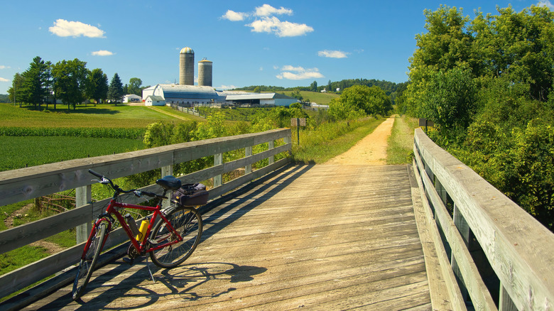 A bridge portion of the Elroy-Sparta Trail with a farm in the background