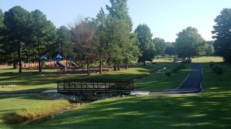 Gene Record Memorial Park in Henderson, Tennessee with small bridge and playground in the background during the day.