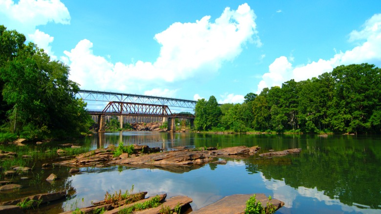 The Tallapoosa River in Tallassee, Alabama, with bridge in background and trees along shore