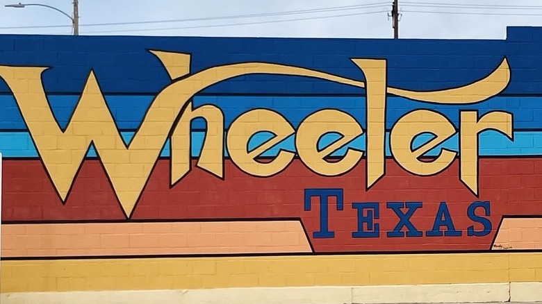Colorful "Wheeler, Texas" mural on brick wall.