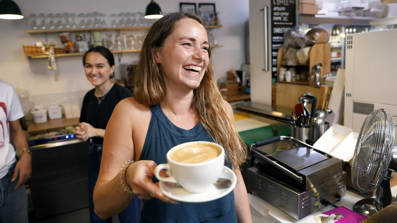 Female cafe waitress with large coffee