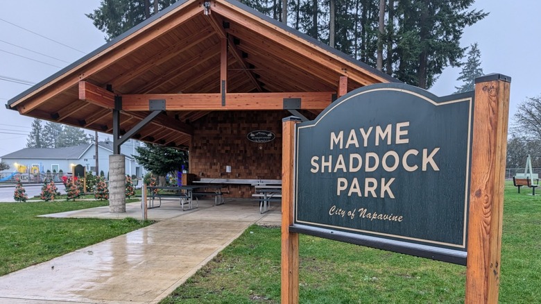 A wooden sign in front of a picnic pavilion reads "Mayme Shaddock Park."