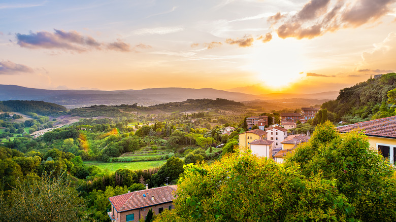 Sunset over a green valley in Tuscany and the town of Chiusi