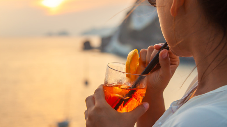 Woman sipping an Aperol spritz on the island of Ponza, in Italy