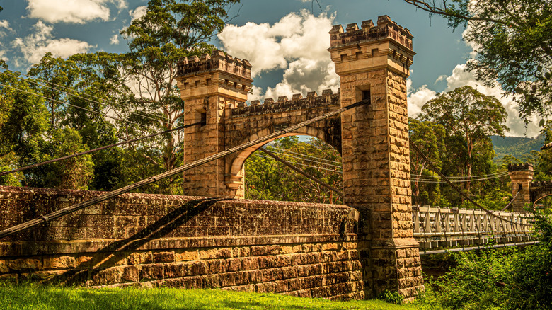 A suspension bridge with sandstone turrets across a rainforest gorge in Kangaroo Valley, Australia