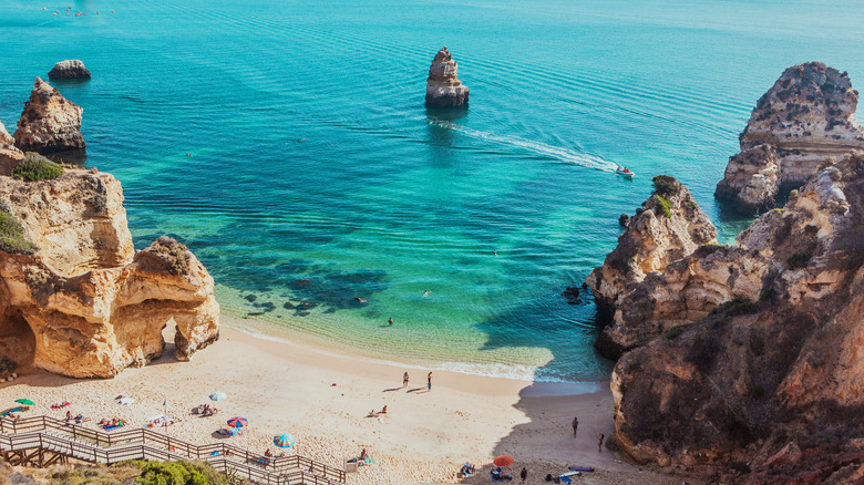 Small beach surrounded by limestone rock formations and turquoise water