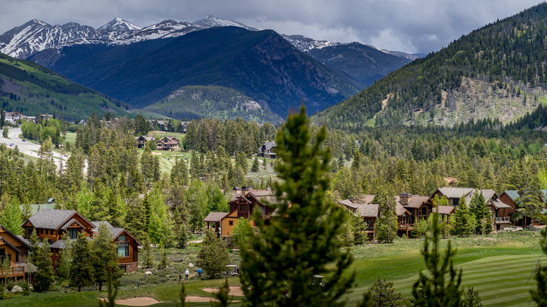 View of Keystone ski resort in the summer, with lake and mountains.