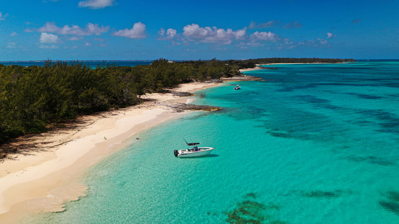 An aerial view of a boat floating in turquoise waters off Rose Island in The Bahamas