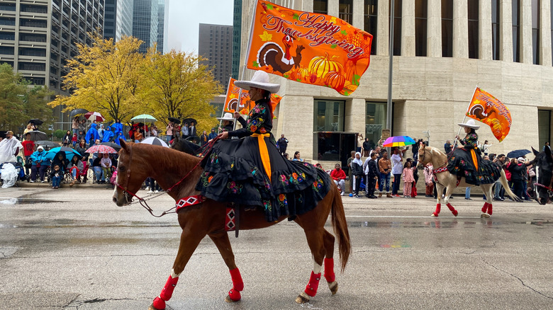 Woman on horse with Thanksgiving sign