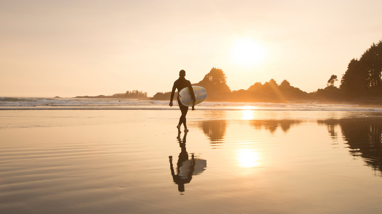 Surfer on the beach in Pacific Rim National Park Reserve, BC, Canada