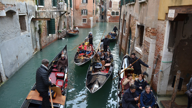 Multiple gondolas in a narrow Venice canal