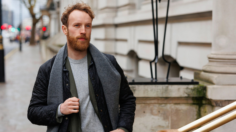 Man in a coat and scarf on a street in London, England