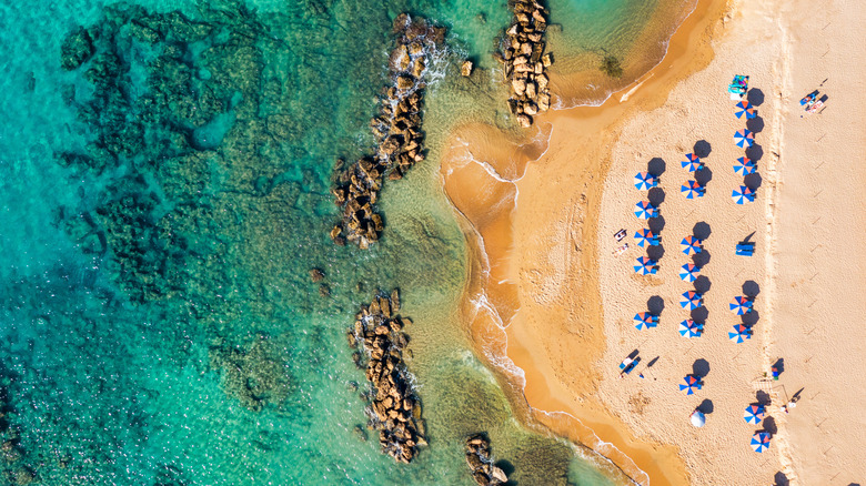 Aerial shot of umbrellas and water on Coral Bay near Pafos, Cyprus.