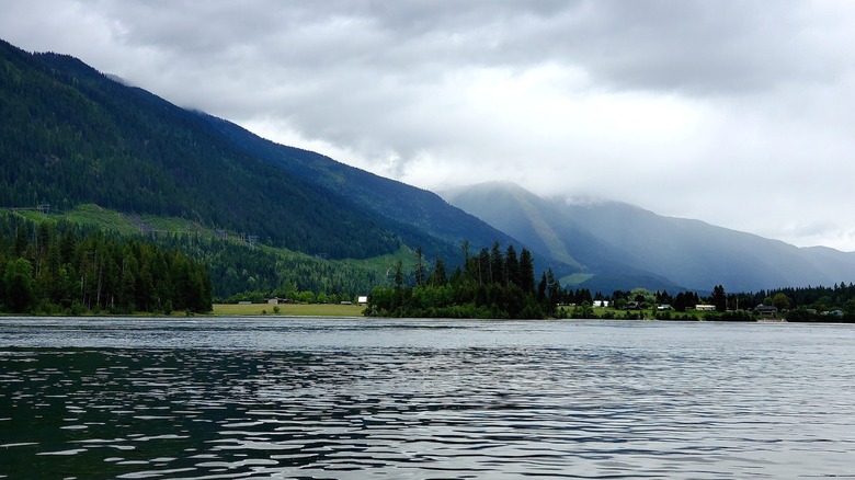 View from the lake of a tiny town at the base of wooded mountains