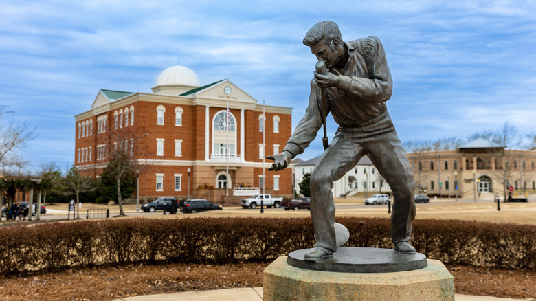 Elvis Presley statue with a red brick building in the back