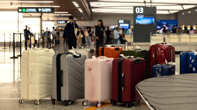 A collection of unclaimed baggage waiting next to a conveyor belt