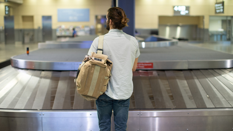 Passenger waiting for their luggage at an empty conveyor belt
