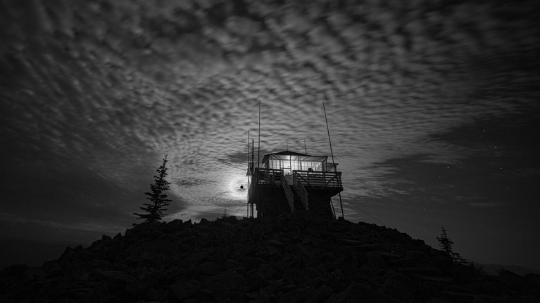 Bumpy clouds form over an Idaho lookout tower, in black and white