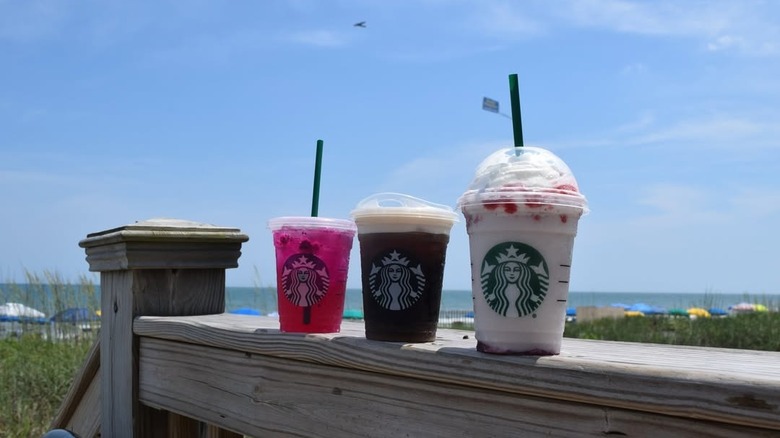 Starbucks beverages on railing with Myrtle Beach ocean view in background