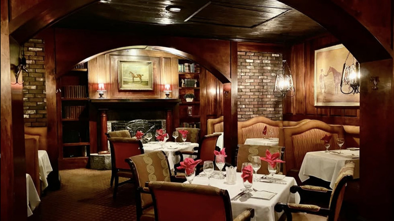 The dimly lit dark wood dining room of Thoroughbreds Chophouse